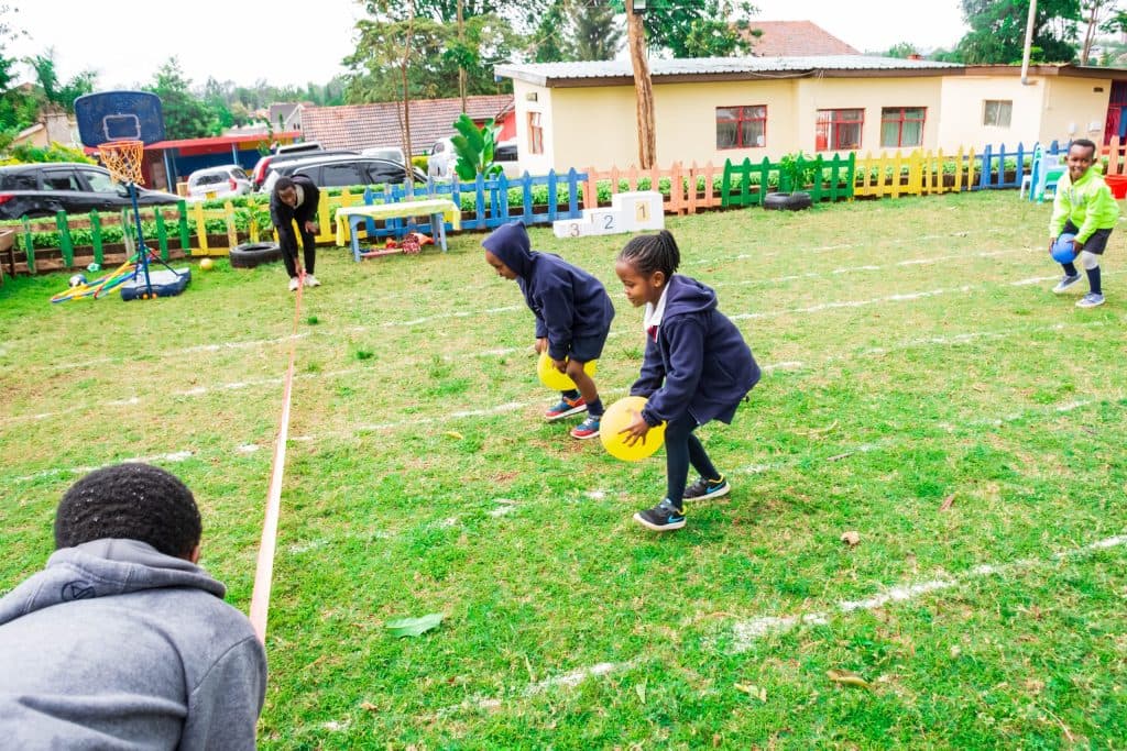 Children in a ball-carry race on the school field